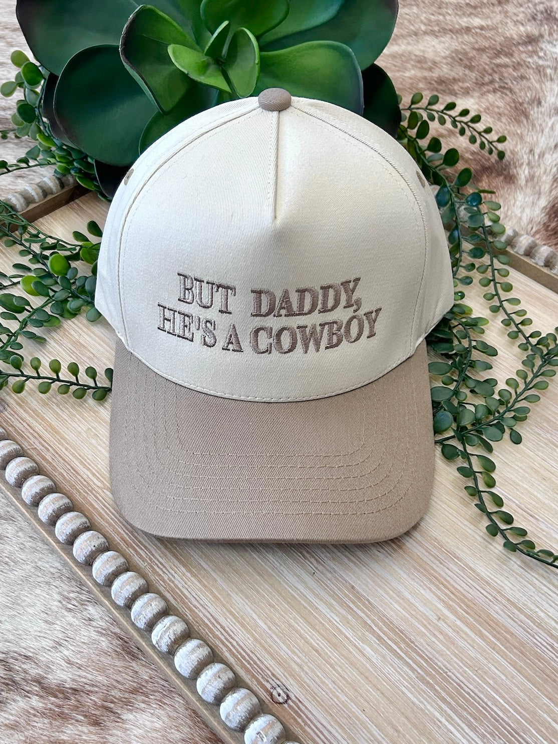 But Daddy, He's A Cowboy Beige Embroidered Trucker Hat